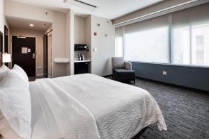 a hotel room with a white bed and a chair at Holiday Inn Express Kansas City Downtown in Kansas City +37 photos