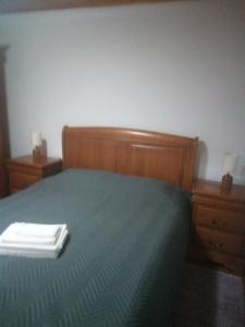 um quarto com uma cama e 2 mesas de cabeceira com uma cómoda em Sobrado Fonseca em Paredes do Rio