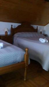 um quarto com 2 camas individuais e lençóis brancos em Sobrado Fonseca em Paredes do Rio