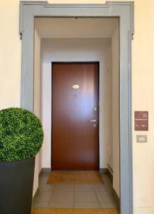 a brown door in a hallway with a plant at B&B Volta in Como