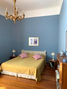 B&B Volta في كومو: غرفة نوم بجدران زرقاء وسرير بمخدات وردية