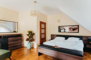 a bedroom with a large bed and a chair at Zarabie Residence in Myślenice