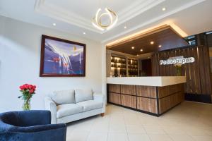eine Lobby mit einem Sofa und einer Rezeption in der Unterkunft Hotel Podocarpus in Loja