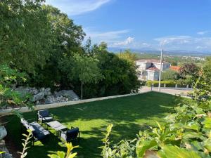 a park with two benches and a grass yard at Apartman IM7 Međugorje in Međugorje