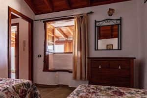 a bedroom with a dresser and a mirror and a window at Casa Rural La Palizada in Benchijigua