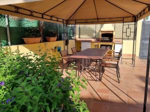 uma mesa e cadeiras sob um guarda-sol num pátio em Villa Maspalomas Golf Court em Maspalomas