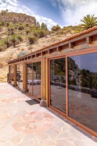 a house with glass doors on a patio at Casa Rural La Palizada in Benchijigua