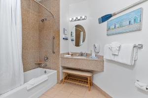 a bathroom with a tub and a sink and a shower at Beach House Inn & Suites in Pismo Beach