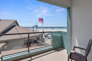 a view of the beach from the balcony of a house at Beach House Inn & Suites in Pismo Beach
