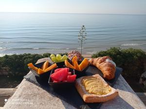 a plate of food with bread and fruit on a table at La riva in Noto Marina