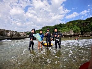 a group of people standing in the water at Liuqiu Hostel 杉橘青年旅店 in Xiaoliuqiu