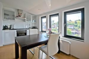 a kitchen with a black table and white chairs at Schönblick in Sankt Andreasberg