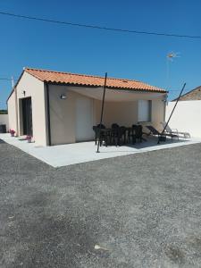 a house with a table and chairs in front of it at L'Instant Présent, en Vendée, gite neuf , 3 etoiles, 15 minutes de l'océan in Saint-Julien-des-Landes