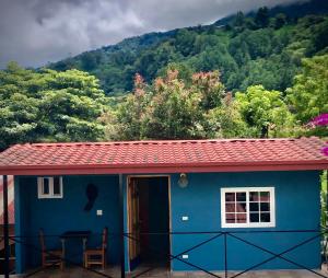 uma pequena casa azul com um telhado vermelho em Toopas em Boquete