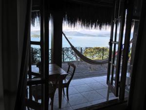 Habitación con vistas, mesa y hamaca. en Casa na Praia com vista para o mar, en Paraty