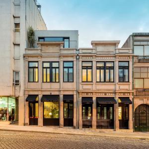 - un grand bâtiment avec des fenêtres donnant sur une rue de la ville dans l'établissement Hotel Tipografia do Conto by Casa do Conto, à Porto
