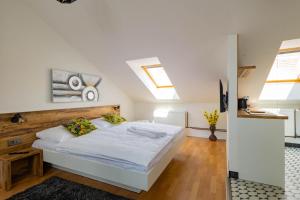 1 dormitorio con cama blanca y cabecero de madera en HighNest apartments, en Bratislava