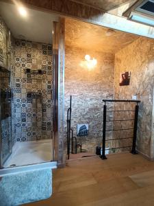 a shower in a room with a stone wall at Mini House in Beauce in Toury
