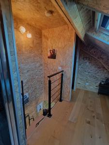 an attic room with a stone wall and a staircase at Mini House in Beauce in Toury