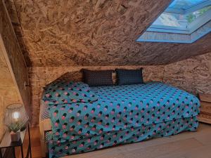 a bedroom with a large blue bed in a stone wall at Mini House in Beauce in Toury