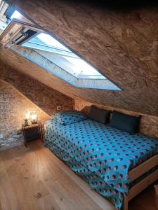 a bedroom with a blue bed in a attic at Mini House in Beauce in Toury
