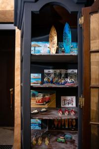 a cabinet filled with lots of toy cars and surfboards at Kais do Sol in Setúbal