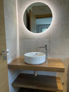 a bathroom with a sink and a mirror at APARTAMENTOS TURÍSTICOS EL RINCONÍN in Llanes