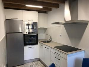 a kitchen with white cabinets and a stainless steel appliance at Casa Cea in Melide