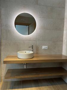 ein Bad mit einem Waschbecken und einem Spiegel in der Unterkunft APARTAMENTOS TURÍSTICOS EL RINCONÍN in Llanes