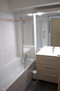 a bathroom with a tub and a shower and a sink at Appartement T3 dans résidence 6 pers in Juzet-de-Luchon