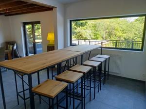 mesa grande y taburetes en una habitación con ventana grande en Zonga Chalet Catan, en Waulsort