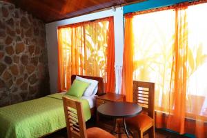 1 dormitorio con cama, mesa y ventana en Isla Azul, en Puerto Ayora