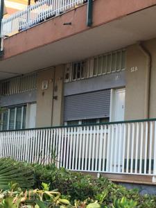 un bâtiment avec une clôture blanche et un balcon dans l'établissement Monolocale Via Nervia, à Vintimille