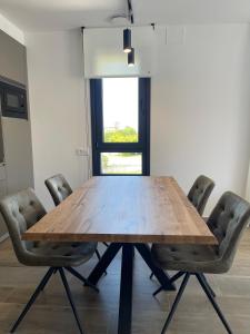 una mesa de madera con sillas en una habitación en APARTAMENTOS TURÍSTICOS EL RINCONÍN en Llanes