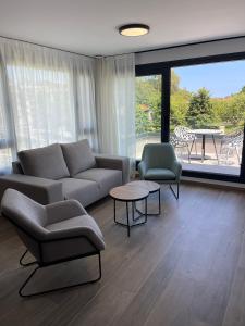 a living room with a couch and chairs and a table at APARTAMENTOS TURÍSTICOS EL RINCONÍN in Llanes