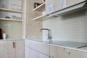 オーステンデにあるCompleet Appartement met Frontaal Zeezicht Oostendeの白いタイル張りの壁、シンク付きのキッチン