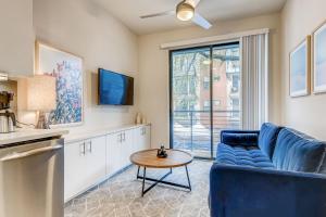 a living room with a blue couch and a table at Sentral East Austin at 1630 E Sixth in Austin