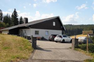 ein Haus mit zwei Autos, die davor geparkt sind in der Unterkunft Schwarzwaldblick in Eisenbach