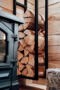 una pila di tronchi sul lato di una casa di The WoodPecker Lodge a Waimes
