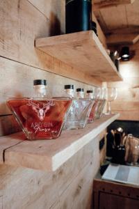 eine Reihe von Glasflaschen auf einer Theke in der Unterkunft The WoodPecker Lodge in Weismes