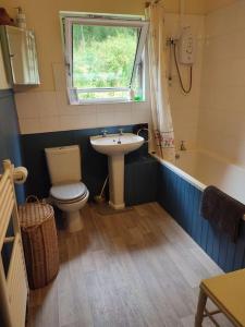 a bathroom with a sink and a toilet and a window at Tobar nan Iasgair Lismore in Achnacroish