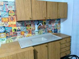 a kitchen with a sink and a wall with stickers at Apartamento Primeira Quadra Da Praia in Praia Grande