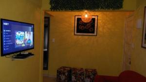 a living room with a flat screen tv on a wall at Apartamento Praia Grande in Praia Grande