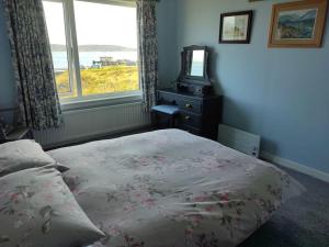 a bedroom with a bed and a dresser and a window at Tobar nan Iasgair Lismore in Achnacroish
