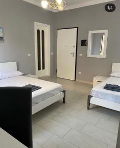 1 dormitorio con 2 camas y puerta al baño en B&B Blu Krimisa, en Cirò Marina