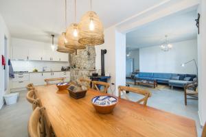 eine Küche und ein Esszimmer mit einem Holztisch und Stühlen in der Unterkunft Eco Villa with Pool in Podaca