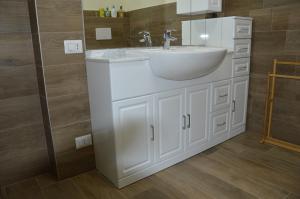 a bathroom with a white sink and a mirror at LA CASA DEL GUARDIA in Lonedo