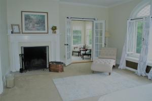a living room with a fireplace and a chair at Franklin Manor in Saranac Lake
