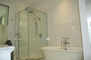 een badkamer met een glazen douche, een bad en een wastafel bij Franklin Manor Bed and Breakfast in Saranac Lake