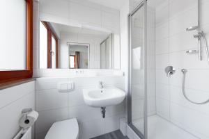 biała łazienka z umywalką i prysznicem w obiekcie Hotel Garni am Olgaeck w Stuttgarcie